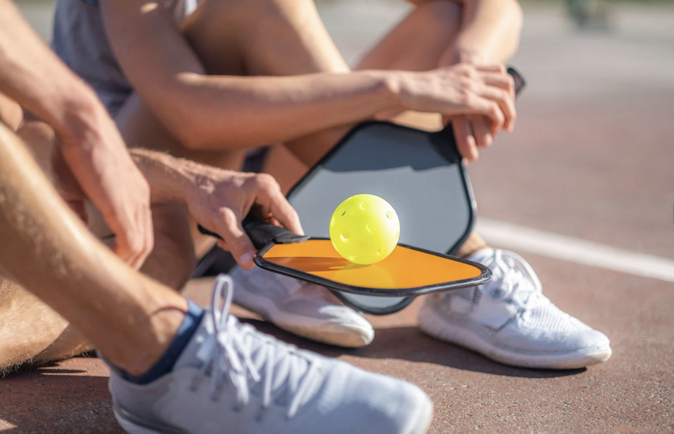 Adults sitting on Pickleball court