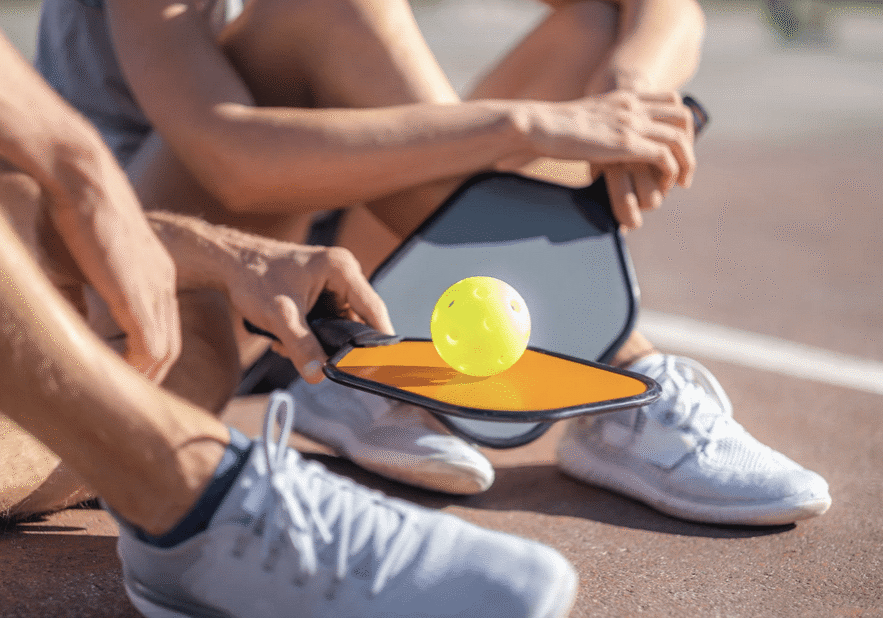 Adults sitting on Pickleball court